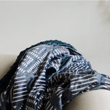 Kijani Throw Blanket in teal with geometric patterned front and solid textured back — large 60" x 80" African-inspired reversible blanket by Sinzia Comfort